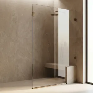 Frameless fixed glass shower panel with warm bronze-tone hardware beside a built-in bench in a walk-in shower