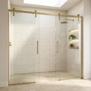 Frameless sliding shower doors on barn-style track hardware in a white tiled walk-in shower